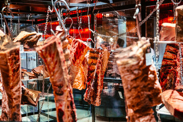 Pieces of fresh raw lamb hanging on hooks in the refrigerator