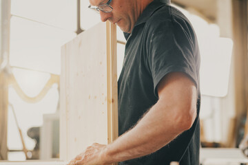 Strength and dedication of woodworker with glasses