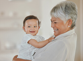 Nanna knows how. Shot of a mature woman holding her grandchild at home.