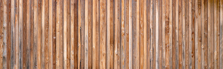Panorama Holzwand aus vertikalen Brettern in verschiedenen Brauntönen, teils leicht verwittert