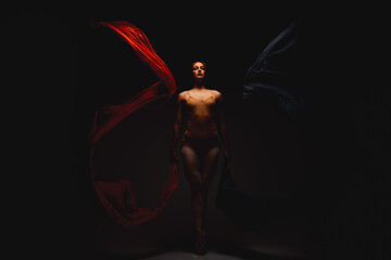 She emanates magic. Shot of a performer dancing against a dark background.