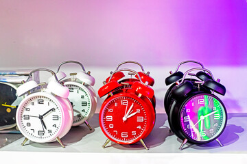 alarm clocks watch white red and black lights in bright pink lighting. Change time to summer or...