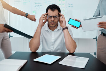 Please go away. Shot of a young businessman looking stressed out while working in a demanding office environment.