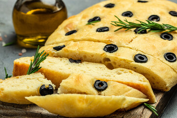 Close up Italian Focaccia with black olives and rosemary. Food recipe background