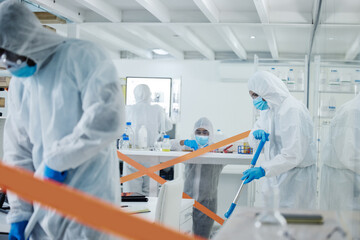 Cleaning up is a team effort. Shot of a group of scientists cleaning up a mess at a lab.