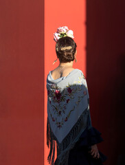 Naklejka premium Título: Mujer vestida de flamenca entrando en la Feria de Abril de Sevilla. 2023 / Woman dressed as a flamenco woman entering the April Fair in Seville. 2023