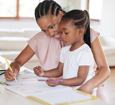 Young african american mother helping her daughter with homework at home. Little girl drawing with her mom at home. Black woman showing her daughter how to write. Small girl learning how to draw