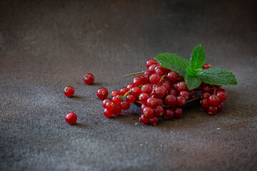 Mix of berries - blueberries and red current on wooden dish on dark brown background 