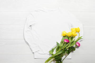 Closeup white blank template sweatshirt hoodie copy space. Mothers women day yellow tulips, pink roses gifts. Happy birthday top view mockup pullover. White wooden background. Flat lay templates