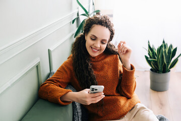 Happy lady browsing e-commerce sites or watching funny videos on a smartphone Enjoying online...