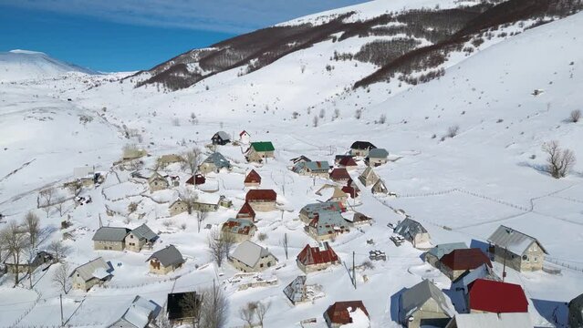 Aerial drone view of mountain village during winter. Snow white landscape and mountaineer lifestyle. 
