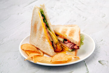 Freshly made ham and cheese sandwich served with potato chips