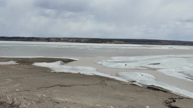 Seasons, spring. Birds fly over the ice of the Berd River, which is beginning to melt. Siberia. Panning.