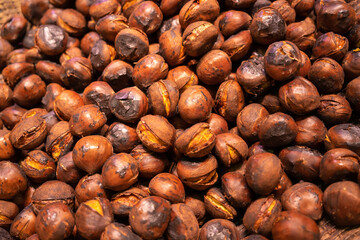 All-over texture of roasted brown chestnuts. Brown background of roasted chestnuts.