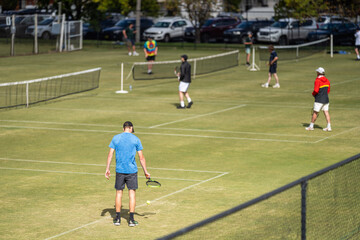 Amateur playing tennis at a tournament and match on grass in Europe 
