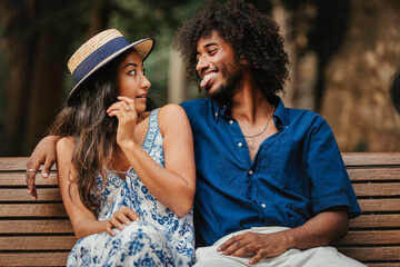 Couple of friends at park for summer holiday, happy date and funny face for social media. Diversity or interracial gen z or young people in nature with profile picture update and emoji kiss.