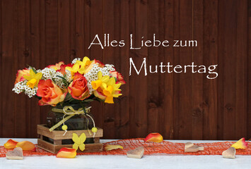 Blumenstrauß vor einer rustikalen Holzwand mit dem Text Alles Liebe zum Muttertag.