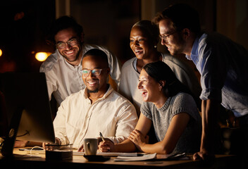 Glad to see everything coming together so well. Shot of a group of businesspeople working together on a computer in an office at night.