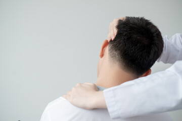 Fototapeta premium Physiotherapist treating male patient with sore throat, Physical therapy concept.