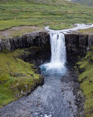 Drone Aerial of Kerlingarfoss Waterfall near Olafsvik on Iceland's Snafellsnes peninsula. High quality photo. Beautiful waterfall with the Snaefellsjokull Volcano in the background.