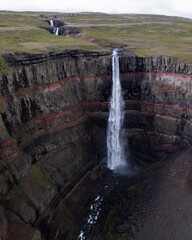 Hengifoss Waterfall in Iceland. High quality photo. Iceland's beautiful red striated rock waterfall. Drone aerial.