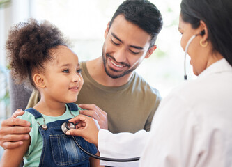 Shes very healthy, dad. Shot of a little girl sitting on her fathers lap while being examined by...
