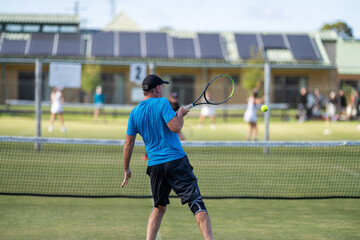 Amateur playing tennis at a tournament and match on grass in Europe 