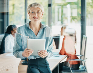 Our meetings are always productive. Cropped portrait of an attractive mature businesswoman using her tablet while standing in the boardroom.