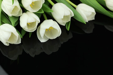 Beautiful bouquet of white tulip flowers with card on black background, space for text