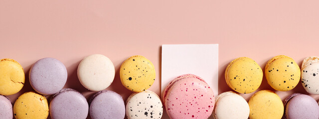 Holiday concept. card for invitation, anniversary , birthday party. frame, mockup copy space. colorful macaroons on beige background. banner