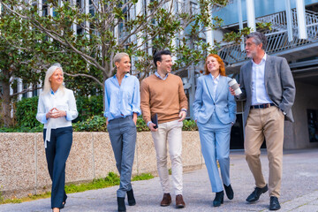 Group of coworkers walking outdoors in a corporate office area, businesswoman and businessman and executives in commercial area