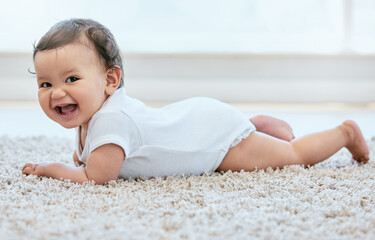 Have snacks. Shot of an adorable baby girl crawling on the floor at home.