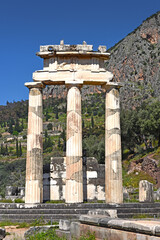 The Tholos of Delphi, a circular temple and one of the ancient structures of the Sanctuary of Athena Pronaia and Apollo temple in the background, Delphi, Greece