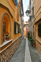 Fototapeta na wymiar A narrow street among the old houses of Sessa Aurunca, a small town of Caserta province, Italy.