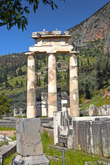 The Tholos of Delphi, a circular temple and one of the ancient structures of the Sanctuary of Athena Pronaia and Apollo temple in the background, Delphi, Greece
