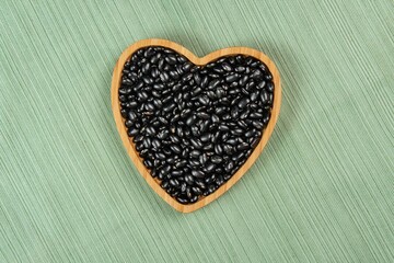 heart shaped black bean bowl on green tablecloth