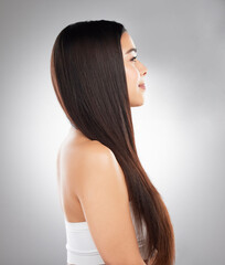 Naklejka premium Good mood stems from a good hair day. Studio shot of a beautiful young woman showing off her long silky hair against a grey background.