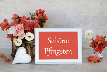 Grußkarte zu Pfingsten: Blumenstrauß mit Herz und dem Text Frohe Pfingsten auf einem Rahmen.
