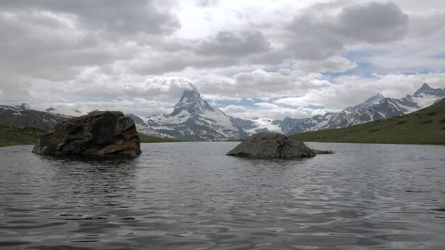 Matterhorn (Monte Cervino, Mont Cervin) pyramid and Stellisee lake in a cloudy day.
