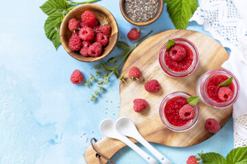 Chia seed pudding with raspberry and jam or smoothies with chia seeds on a stone table. Healthy breakfast. View from above. Copy space.