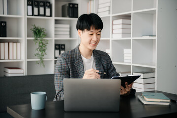 Portrait of young man sitting at his desk in the office