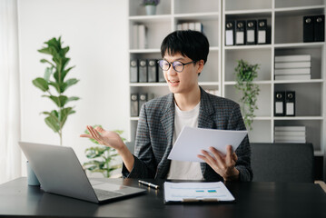Portrait of young man sitting at his desk in the office