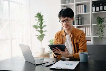Portrait of young man sitting at his desk in the office