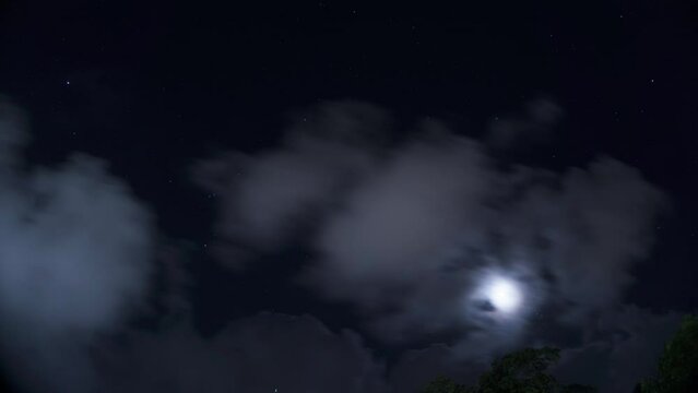 Zeitraffer vom Sternenhimmel mit Mond und Wolken bei Nacht in Puerto Morelos in Mexiko