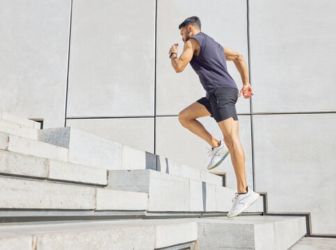 Head up and aim high. Low angle shot of a sporty young man running up a staircase while exercising outdoors.