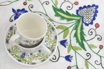 Kashubian traditional pattern on a cup and on a  tablecloth. Floral art.