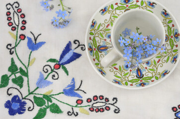Floral, traditional, ethnic pattern on cup and on tablecloth. Kashubian folklore.