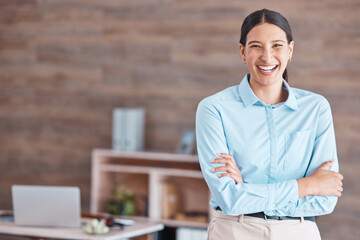 Young happy cheerful mixed race businesswoman smiling while standing with her arms crossed alone in...