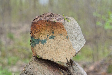 one old piece of gray brown dirty brick stands on a table in the street