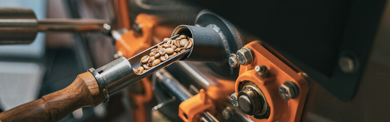Close up of business owner hands operating modern coffee bean roasting machine